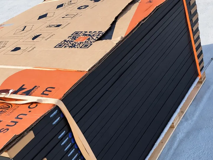 Un pallet di pannelli fotovoltaici imballati, appena arrivato sul tetto